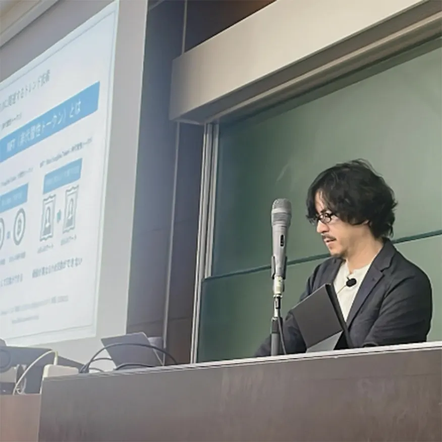 マイクを手に講演する当社代表